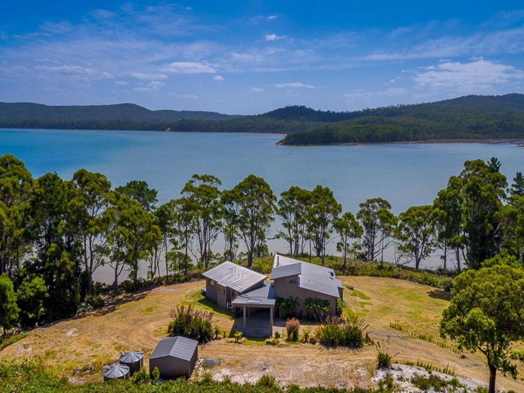eine Luftansicht eines Hauses auf einem Hügel neben einem See in der Unterkunft Cloudy Bay Lagoon Estate in South Bruny