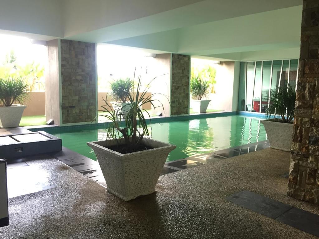 a swimming pool with potted plants in a building at Apartment Wakaf Che yeh in Kota Bharu