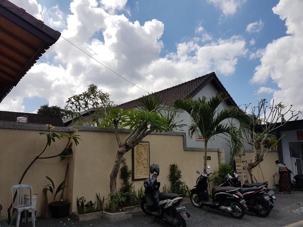 Nyoman Guesthouse Berawa Canggu في تشانغو: اثنين من الدراجات النارية متوقفة أمام منزل