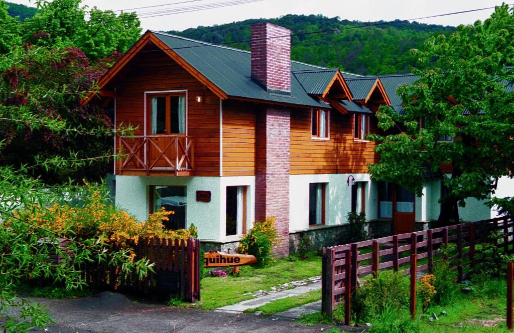 una casa de madera con una valla delante en Cabañas Quilquihue en San Martín de los Andes