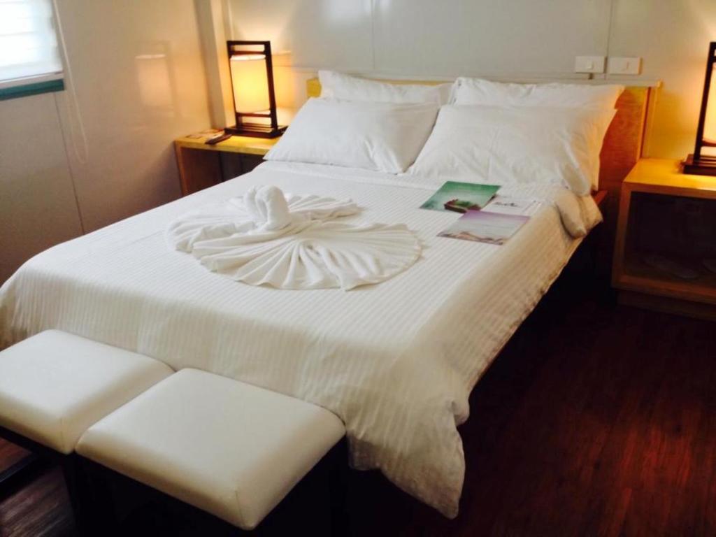 a large white bed with a heart decoration on it at Shore Time Hotel - Annex in Boracay