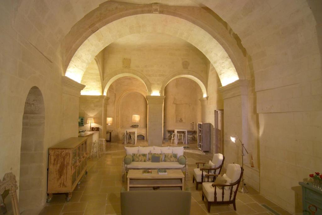 een woonkamer met een bank en stoelen in een gebouw bij L'Hotel In Pietra in Matera
