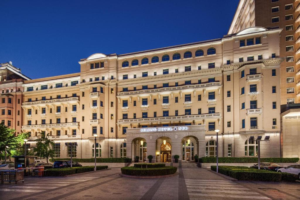 a large white building with a courtyard in front of it at Beijing Hotel NUO Forbidden City in Beijing