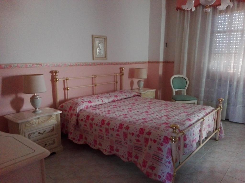 1 dormitorio con 1 cama, 2 mesas y 1 silla en B&B Lago Mulargia, en Siùrgus Donigala