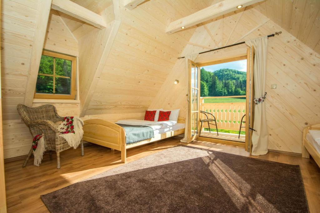 sypialnia z łóżkiem i oknem w kabinie w obiekcie Domek Trzy Doliny Zakopane - Three Valleys Chalet Grill&Jacuzzi w Zakopanem