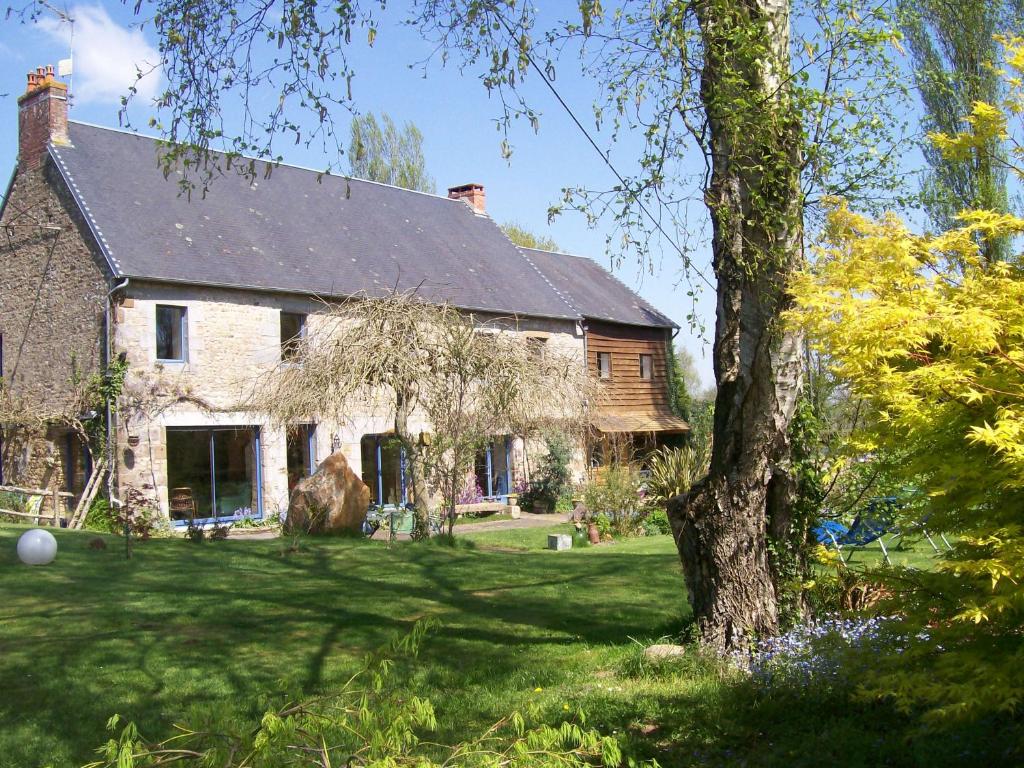 Noirpalu的住宿－Les Rhodos，院子里有树的砖房
