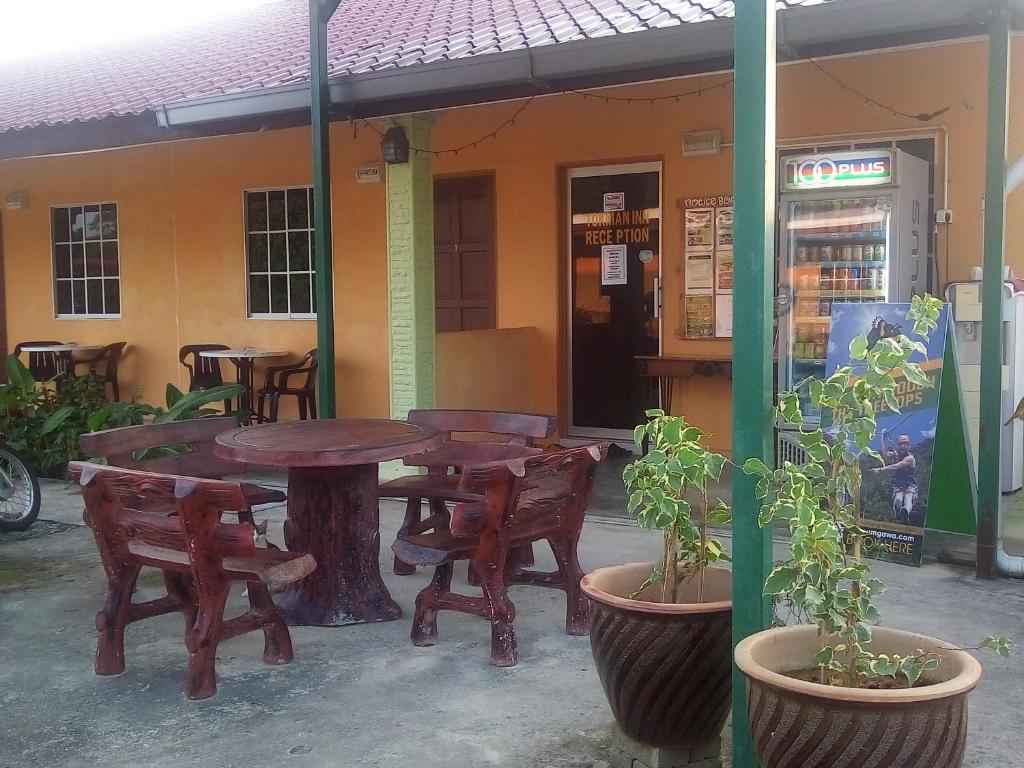 a table and chairs in front of a restaurant at Tokman Inn in Pantai Cenang