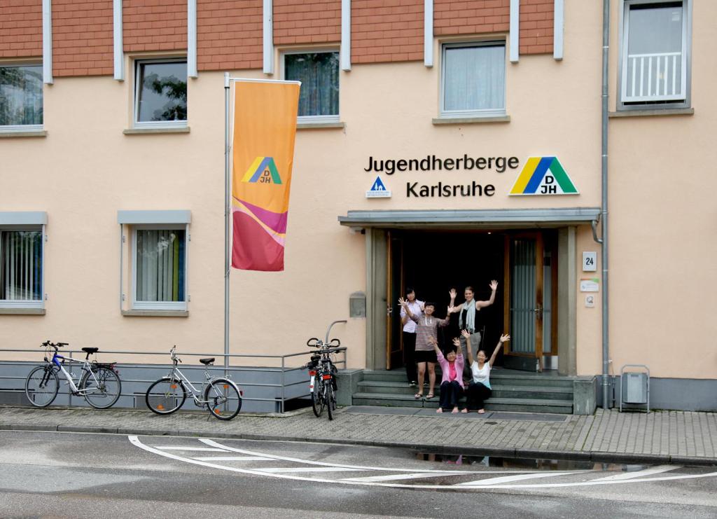 un grupo de personas parados fuera de un edificio en Jugendherberge Karlsruhe, en Karlsruhe