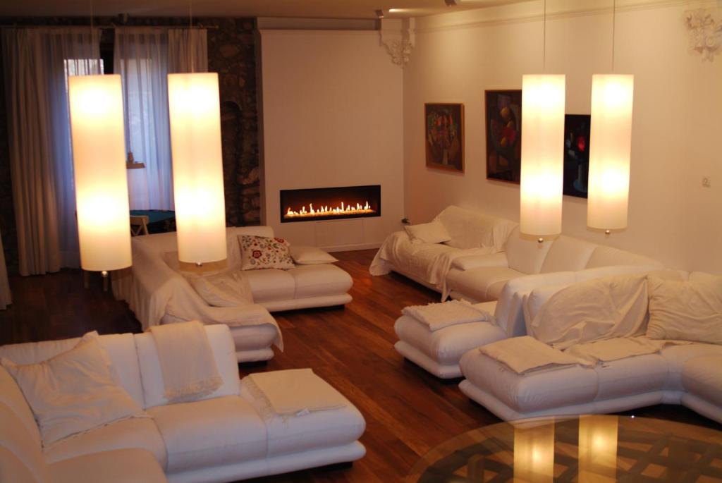 ein Wohnzimmer mit weißen Sofas und einem Kamin in der Unterkunft El Castell de la Pobla de Lillet (Adults Only) in La Pobla de Lillet