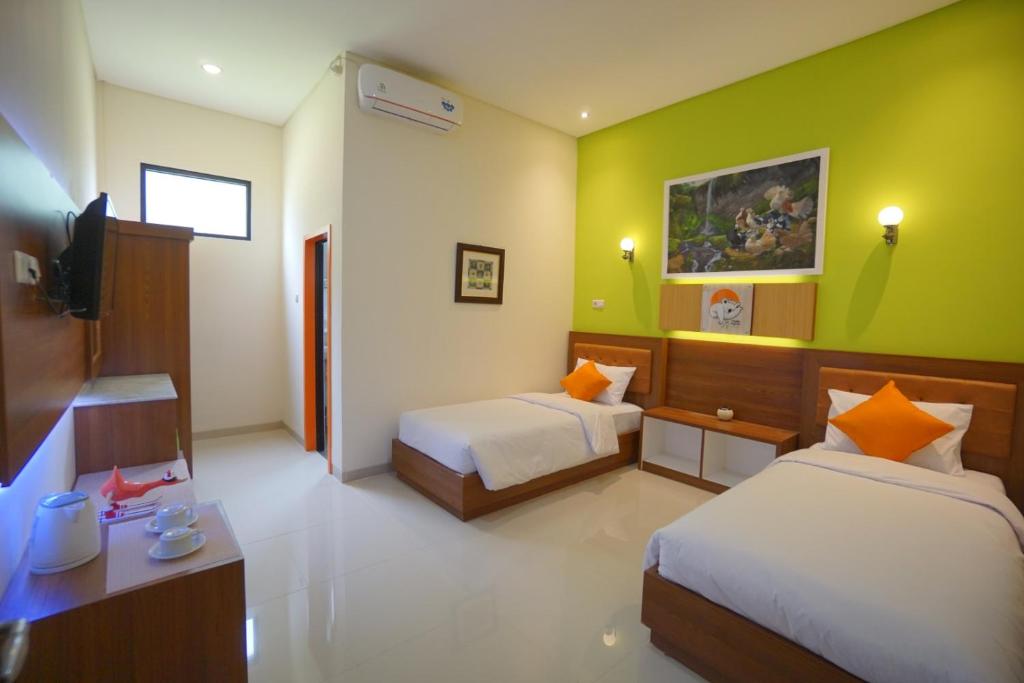 Postel nebo postele na pokoji v ubytování The Cabin Tanjung Hotel Wonosobo