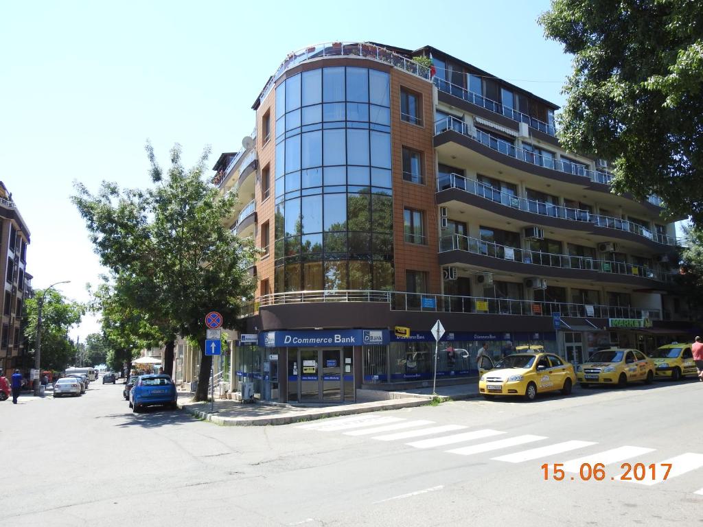 a building on a street with cars parked in front of it at Sunny Sands Studios in Burgas City