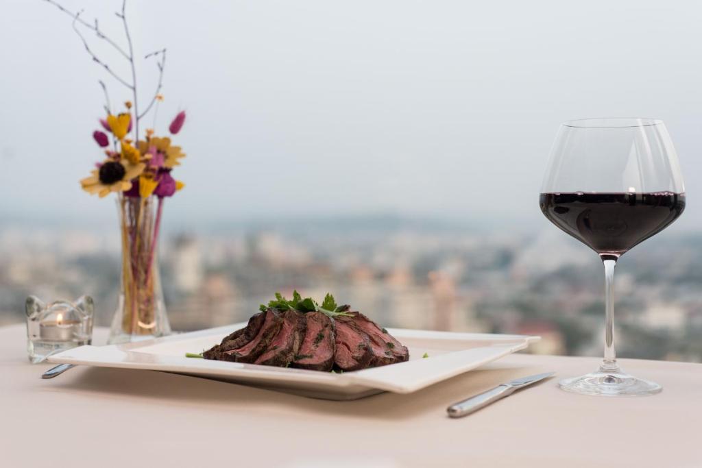 a plate of steak and a glass of wine at Unirea Hotel & Spa in Iaşi