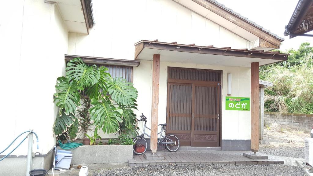 a bike parked outside of a house with a door at Minshuku Nodoka in Yakushima