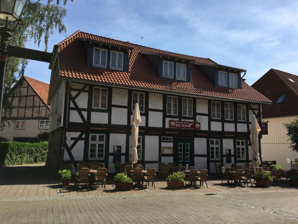 a building with chairs and umbrellas in front of it at Haus Heinrich Heine in Ilsenburg