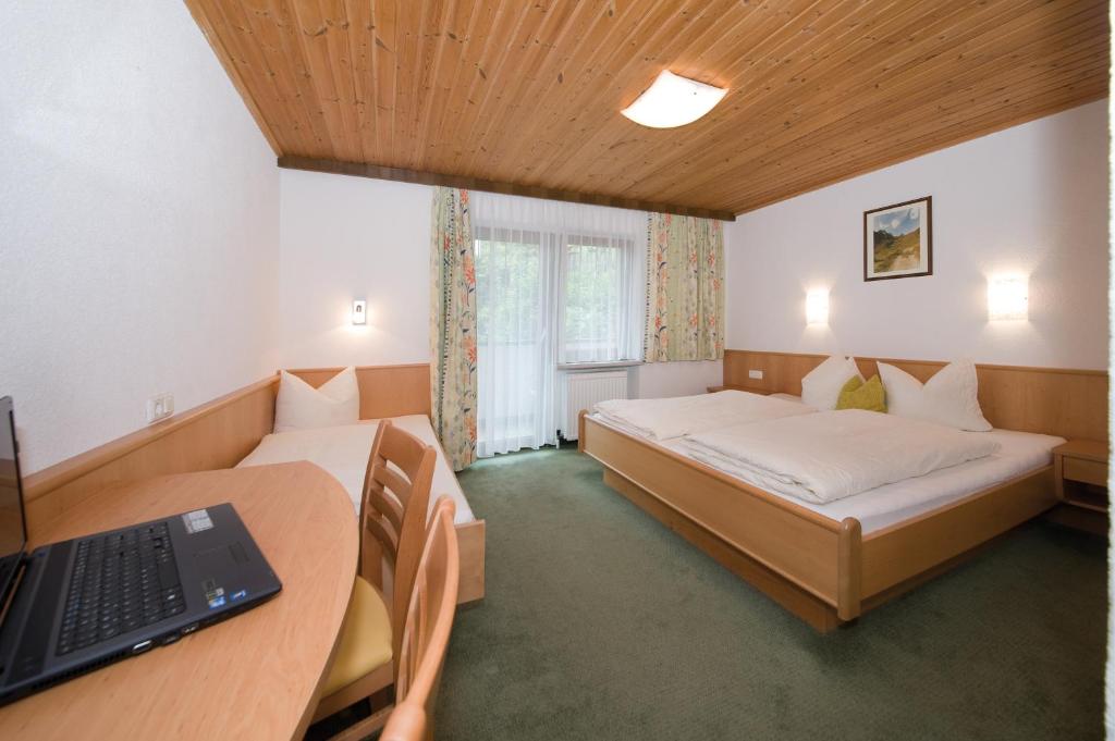 カップルにあるGarni-Austria Kapplのベッドルーム1室(ベッド2台、ノートパソコン付きのデスク付)