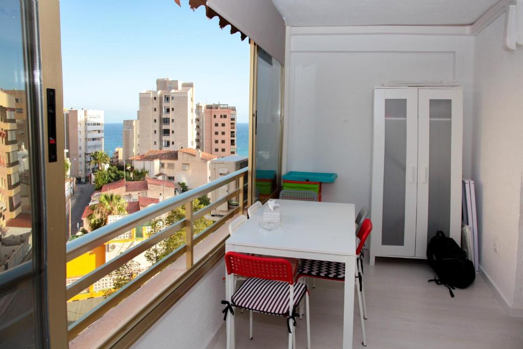 a balcony with a table and chairs and a view of the city at La Cala Finestrat Apartment in Cala de Finestrat