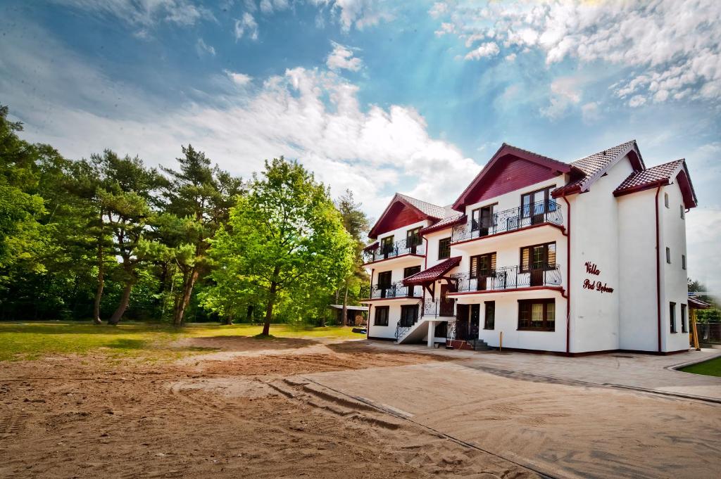 a large white building with a red roof at Willa pod Dębem in Rozewie