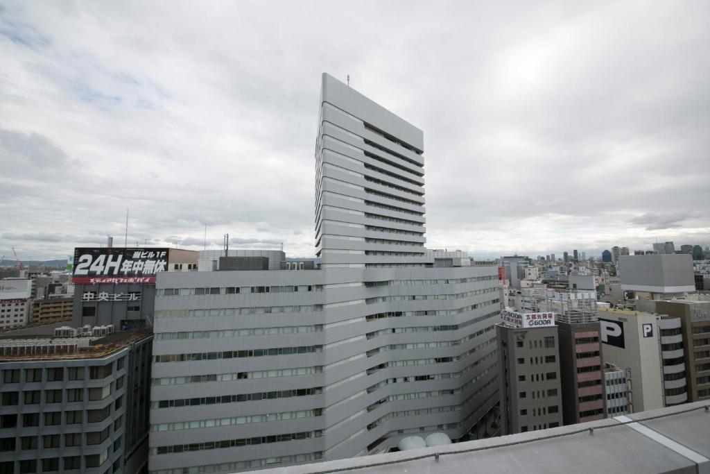ein hohes weißes Gebäude auf der Spitze einer Stadt in der Unterkunft Shin Osaka Washington Hotel Plaza in Osaka