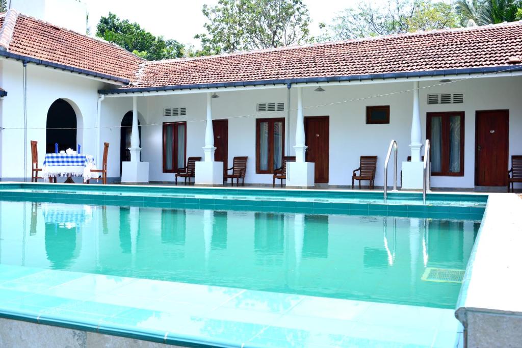 a swimming pool in front of a house at Paradise Forest Garden in Matale
