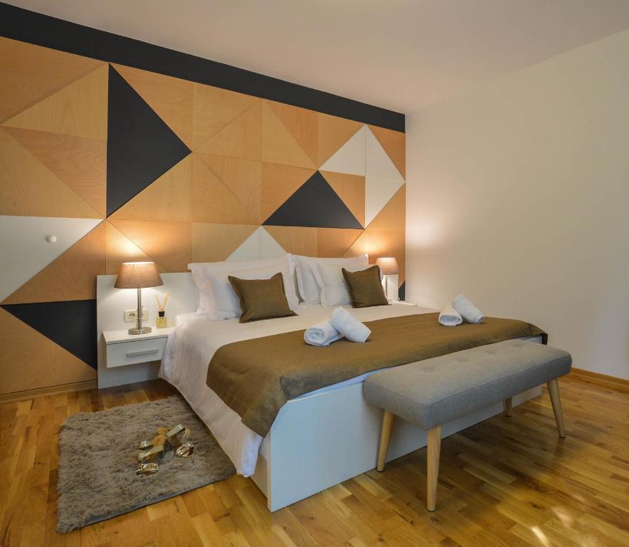 1 dormitorio con 1 cama grande y pared geométrica en Kolombo Lux apartment, en Split