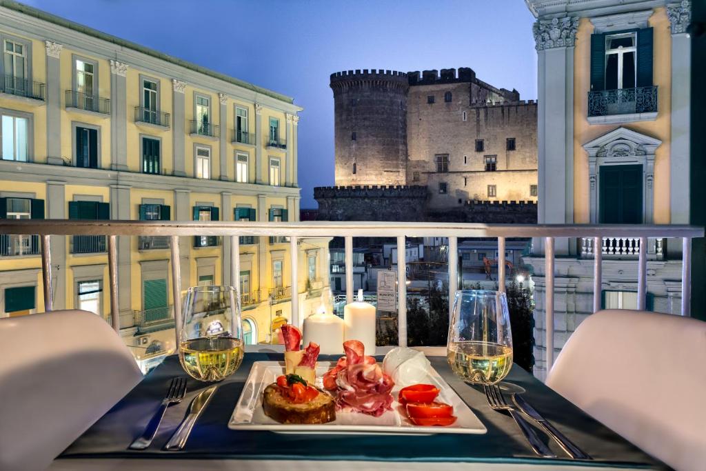 un tavolo con un piatto di cibo su un balcone con castello di Carten a Napoli