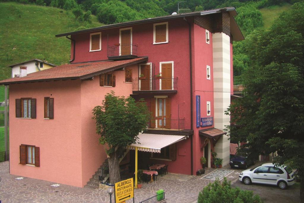 a red building with a car parked in front of it at Albergo Belvedere in Collio