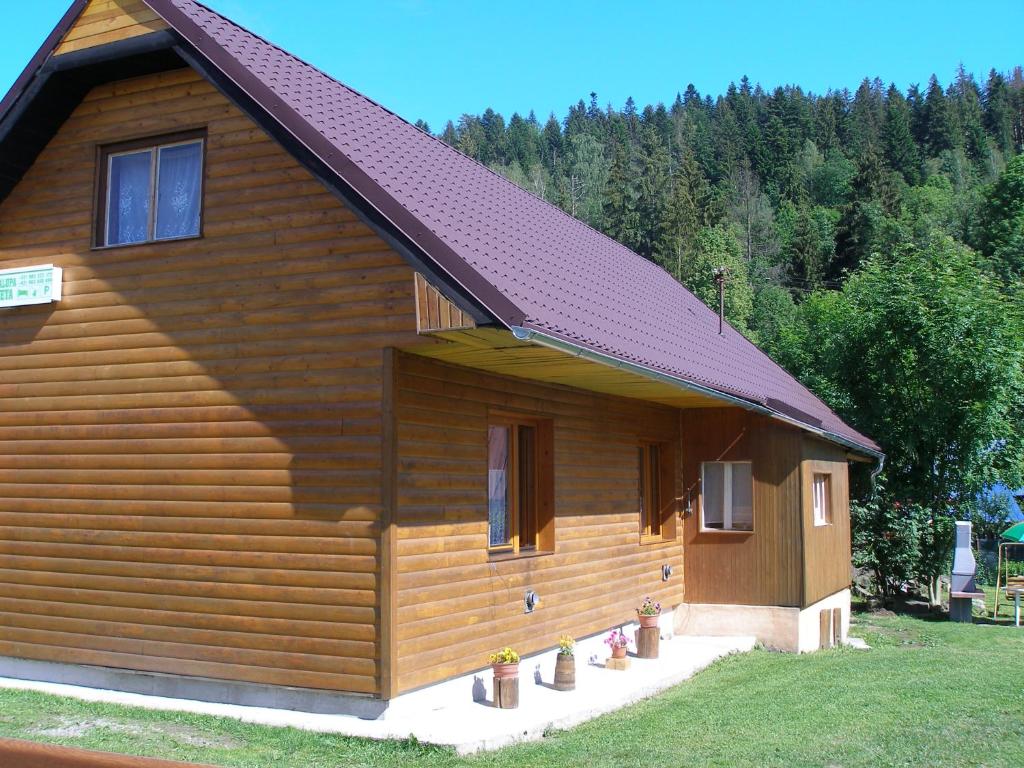 a log cabin with a red roof and a porch at Chalupa Iveta in Oščadnica