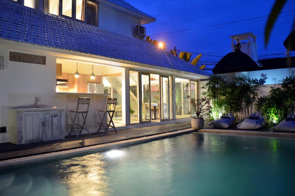 ein Swimmingpool vor einem Haus bei Nacht in der Unterkunft Villa Oberoi in Seminyak