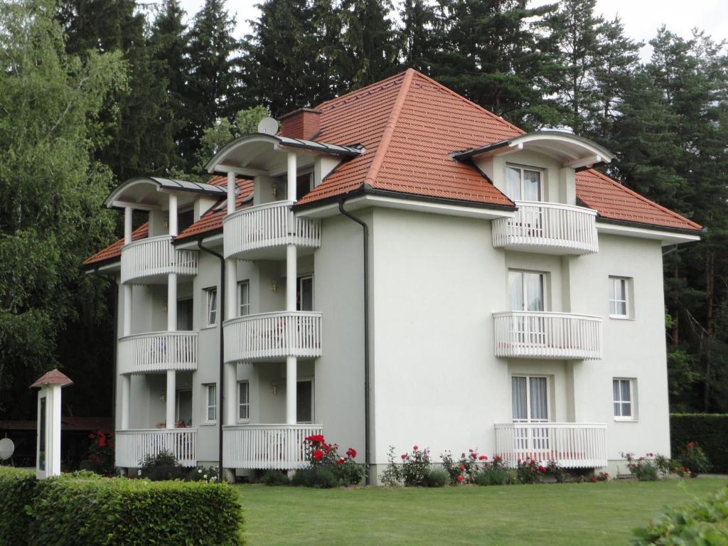 ein großes weißes Apartmenthaus mit rotem Dach in der Unterkunft Ferienwohnung Rogatsch in Sankt Kanzian am Klopeiner See