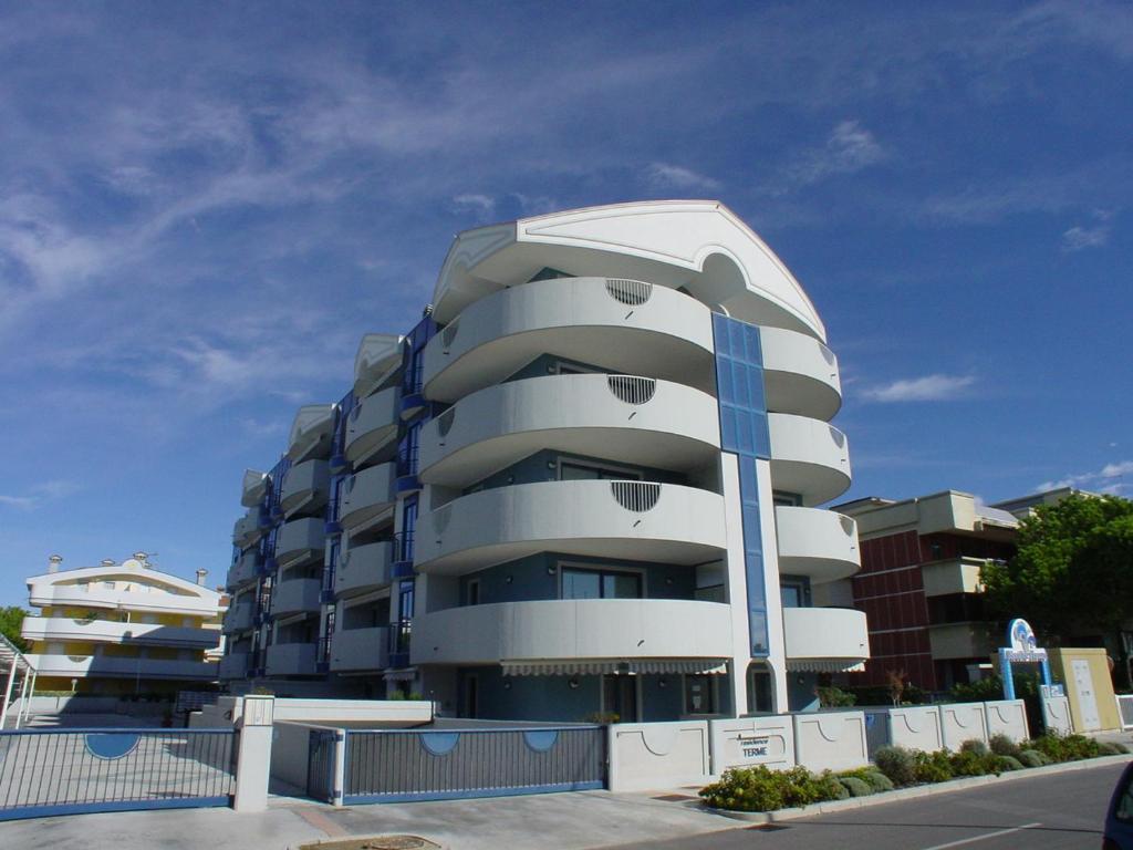 a white apartment building with a domed at Residence Terme in Grado