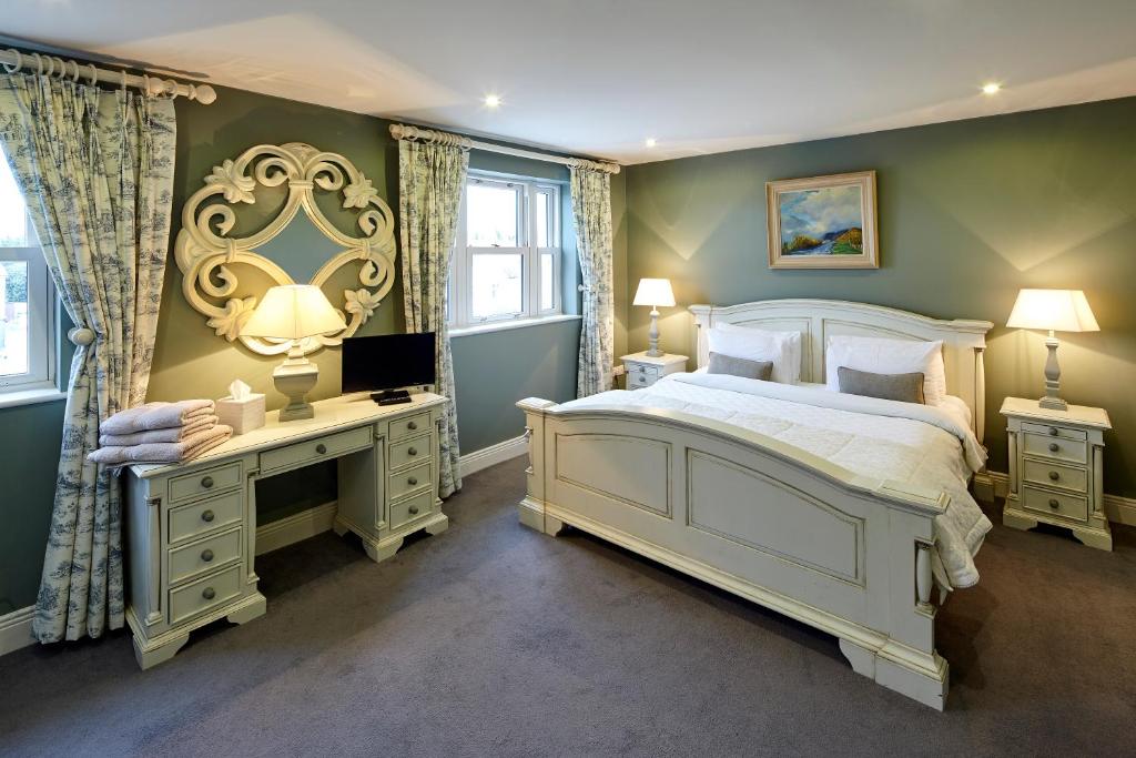 a bedroom with a bed and a desk with a television at Horse & Hound in Delgany