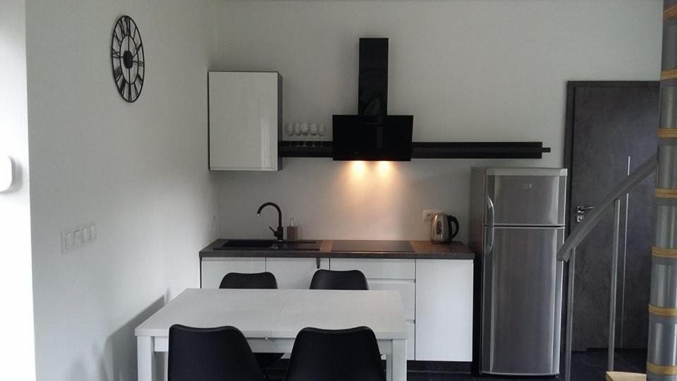 uma cozinha com uma mesa e cadeiras brancas e um frigorífico em Domki Heaven Kujanki em Kujanki