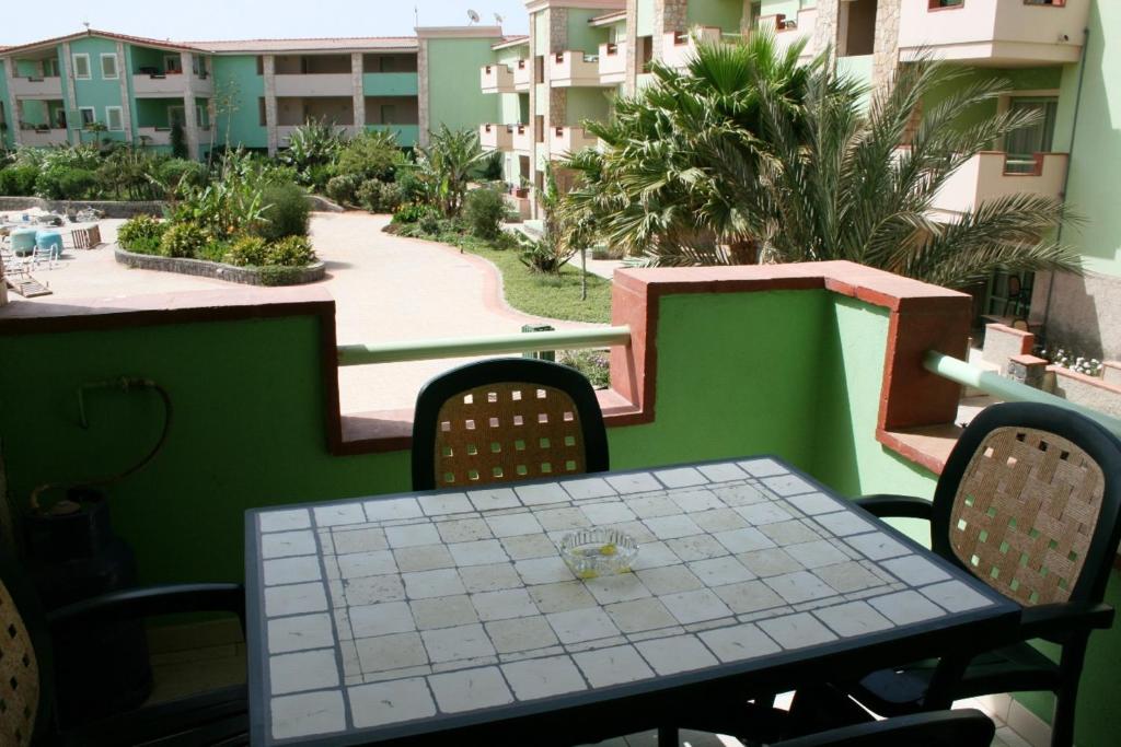 una mesa y sillas en un balcón con vistas en Djasal Moradias Apartment, en Santa Maria