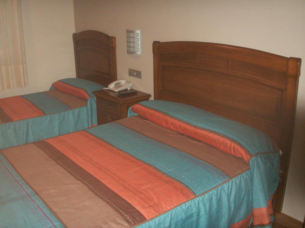 A bed or beds in a room at Hostal La Nava
