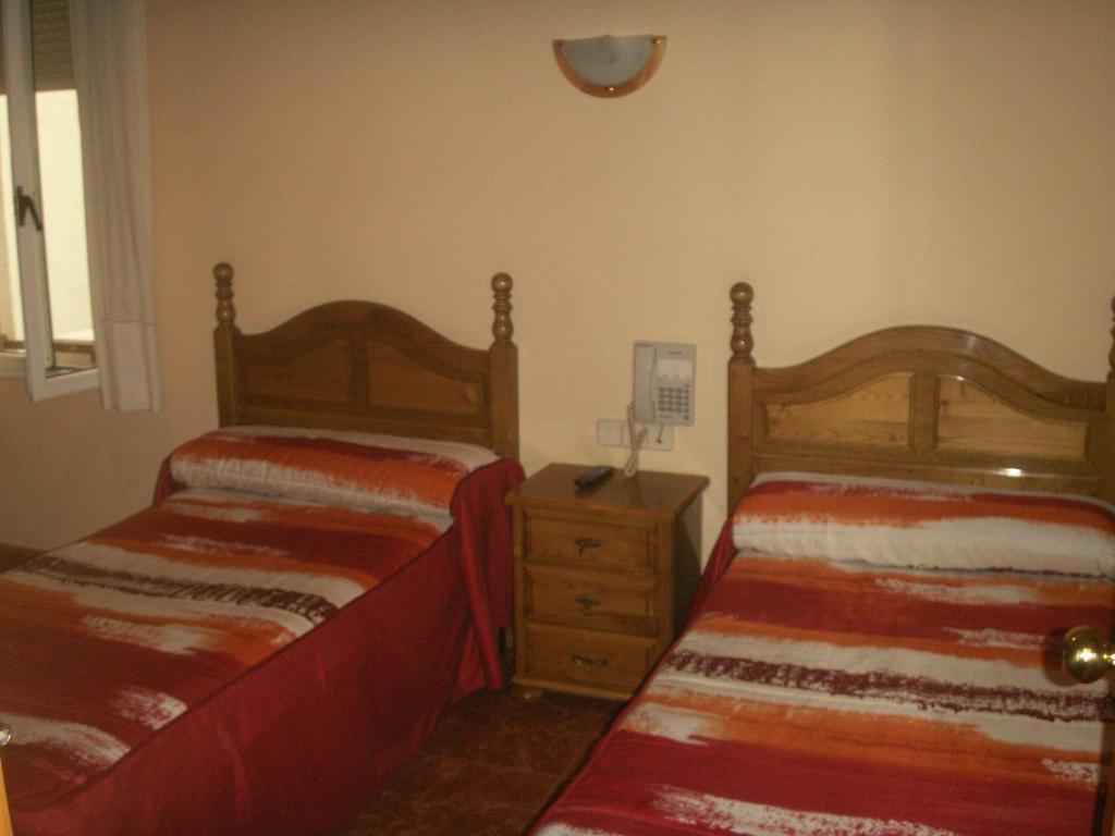 A bed or beds in a room at Hostal La Nava