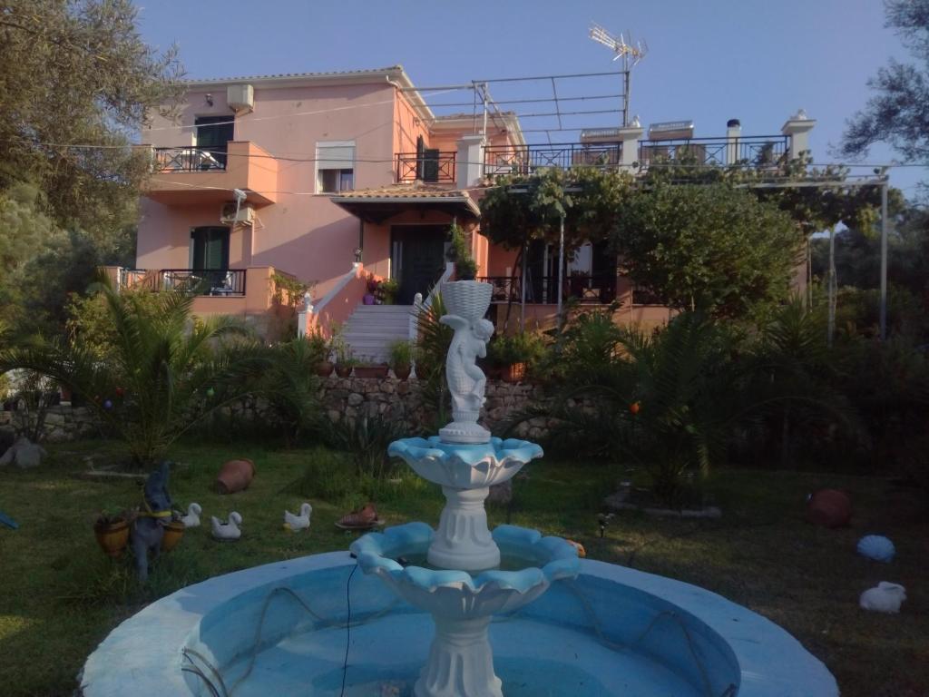 a fountain in a yard with a house in the background at Ellis Studios in Meganisi