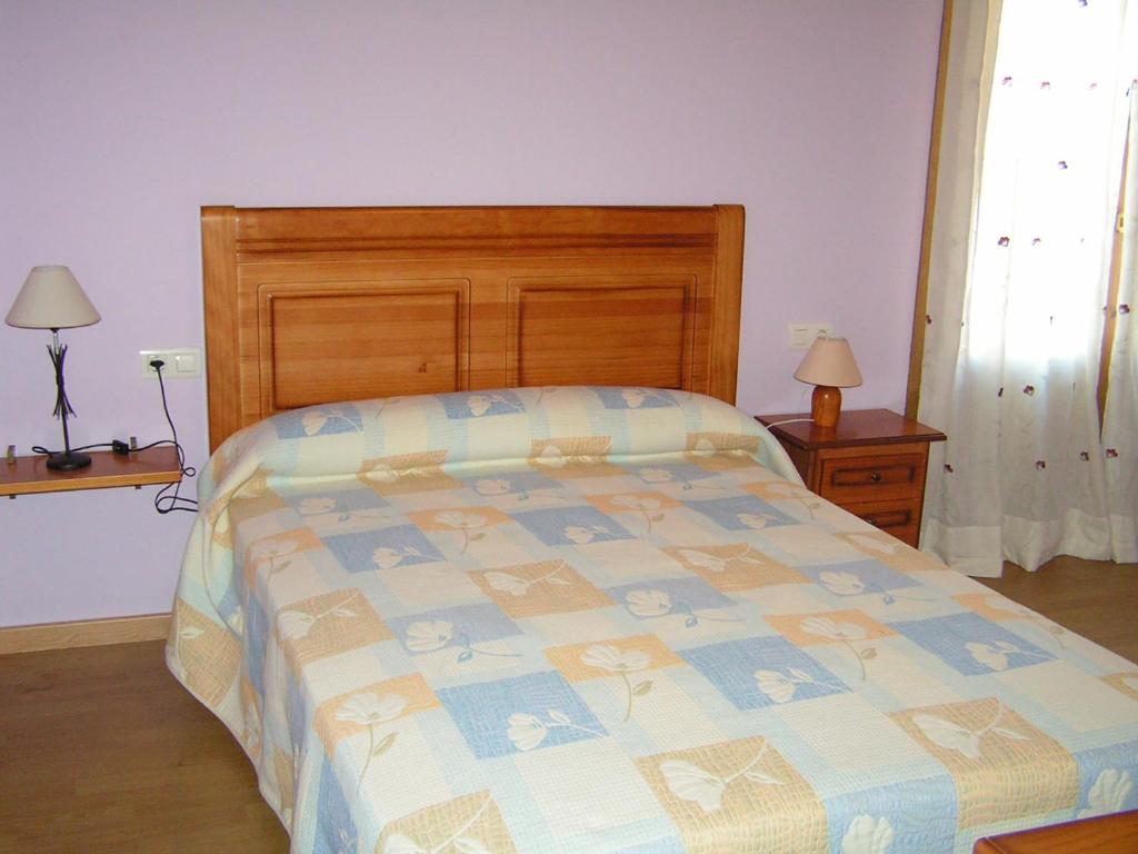 a bedroom with a bed with a wooden head board at Casa lo Sastre - Jasa in Jasa