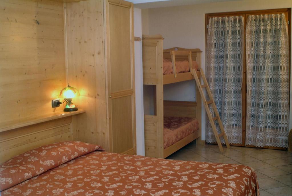 a bedroom with two bunk beds and a ladder at Hotel Sole in Castione della Presolana