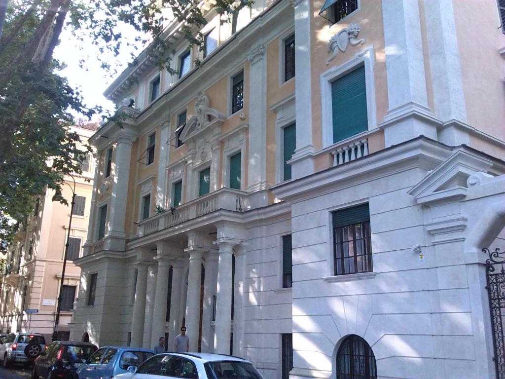 un edificio blanco con coches estacionados frente a él en Agnes Roma, en Roma
