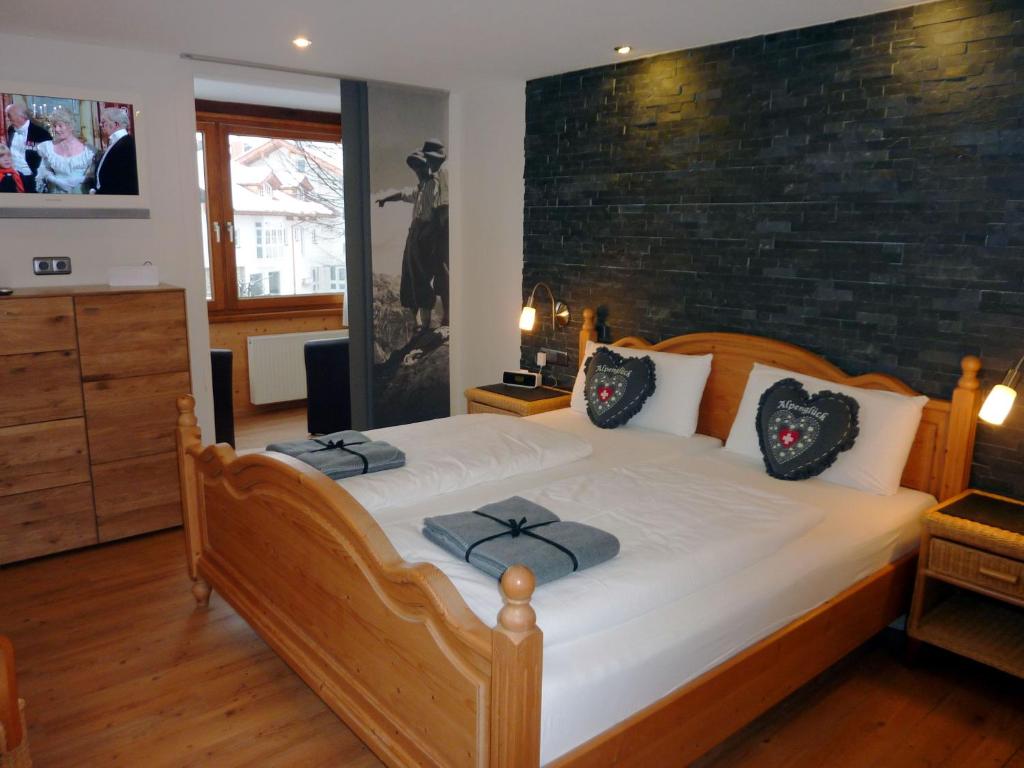 a bedroom with a large bed with a brick wall at Hotel Engel in Oberstdorf