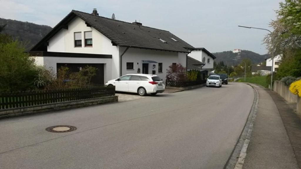 ein weißes Auto, das vor einem weißen Haus parkt in der Unterkunft Ferienwohnung am sonnigen Hang in Riedenburg