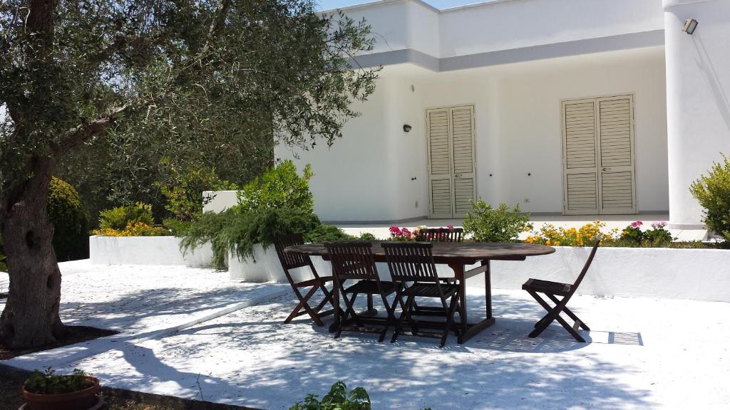 een patio met een tafel en stoelen in een tuin bij Tenuta Schiauddi in Bagnolo del Salento
