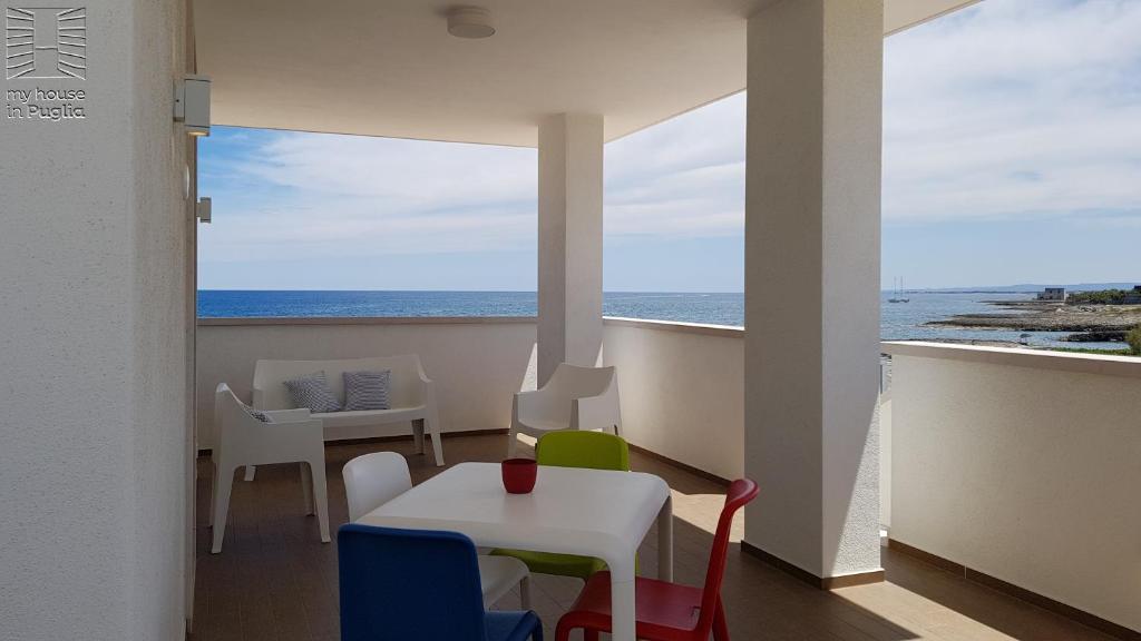 a room with a table and chairs and a view of the ocean at Case Vacanza Marzano in Monopoli