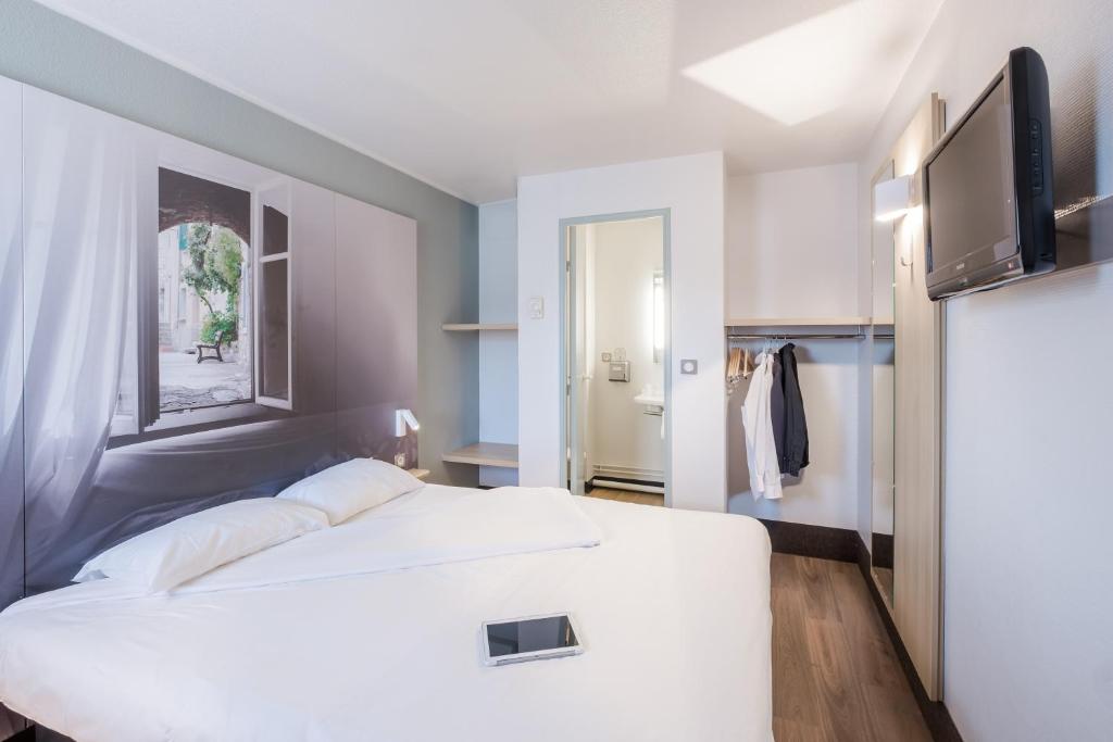 A bed or beds in a room at B&B HOTEL Valence Nord