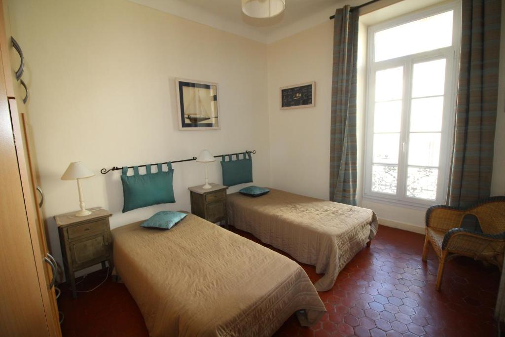 ein Hotelzimmer mit 2 Betten und einem Fenster in der Unterkunft AGENCIA apartement 3 PIECES RUE D'ANTIBES in Cannes