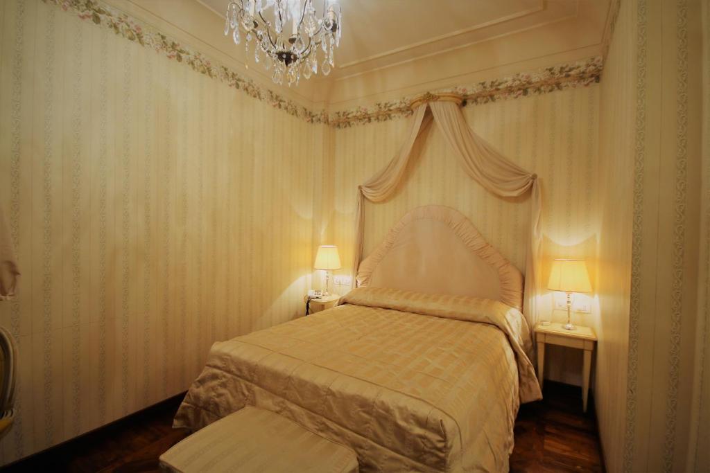 a bedroom with a bed and a chandelier at Albergo Tre Pozzi in Fontanellato