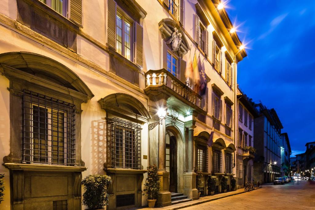 a city street with tall buildings and a clock on the side of it at Relais Santa Croce, By Baglioni Hotels in Florence