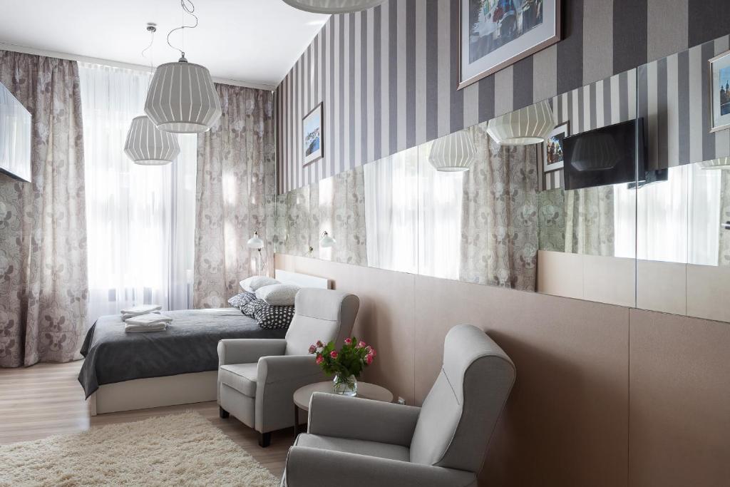 a bedroom with a bed and a couch and a chair at Apartament Monte Cassino w Sopocie in Sopot
