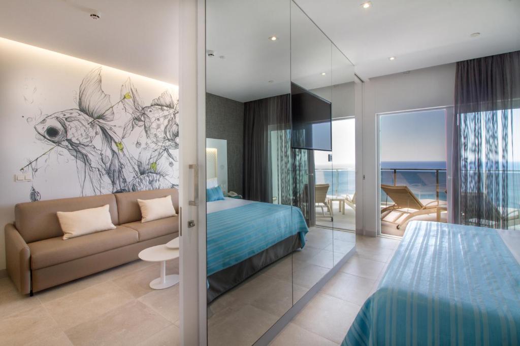 a bedroom with a bed and a couch in a room at ESTIMAR Calpe Suitopia in Calpe