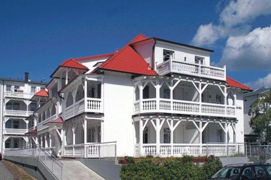 a large white building with a red roof at Haus Strandburg in Binz